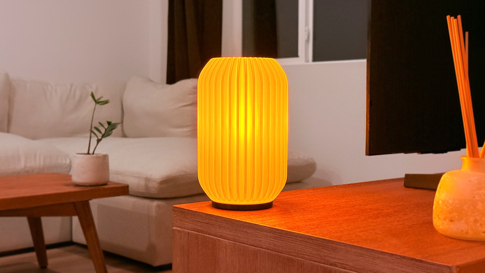 Scenic view of Kei 3D printed modern tabletop lamp in a living room, showing sculpted spiral design and ambient lighting