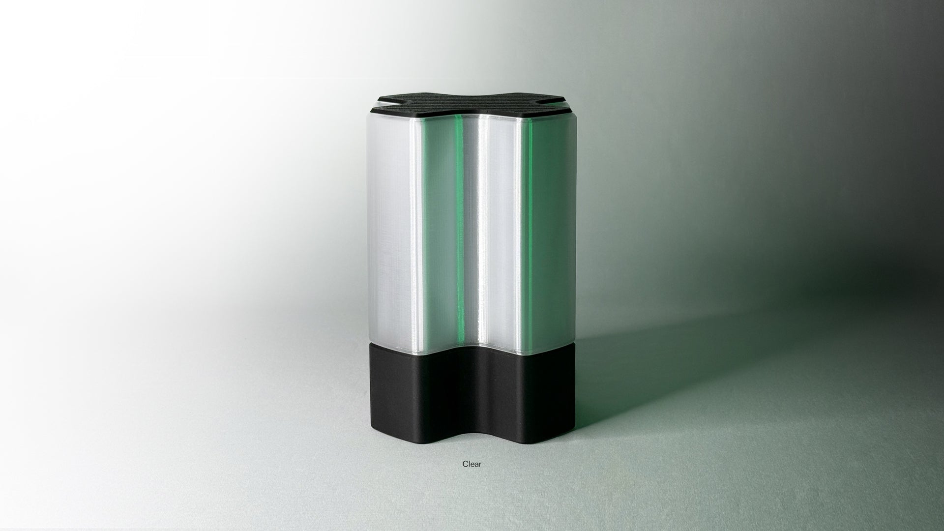 Front angled view of Nebu 3D printed modern tabletop lamp in clear shade, showing double-walled transparent design with lamp off