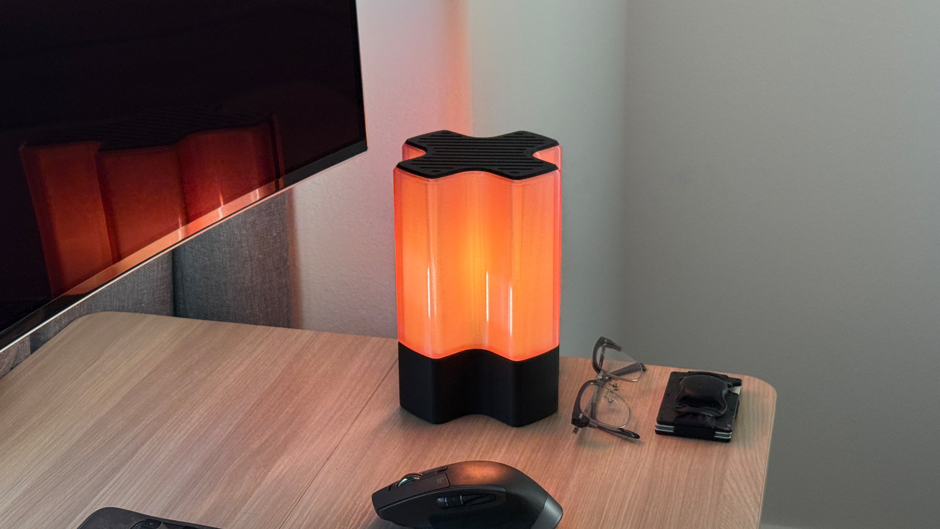 Front three-quarter view of Nebu 3D printed modern tabletop lamp in Cozy Pink shade, shown on with soft ambient light